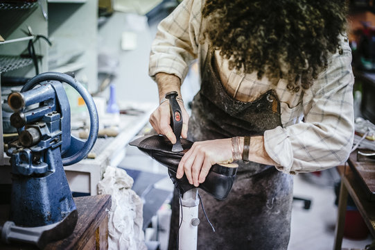 shoemaker adjusts shoe sole in his workshop