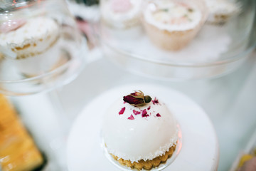 Hand made delicious cakes with bud roses, decorated at a wedding dessert table. Idea