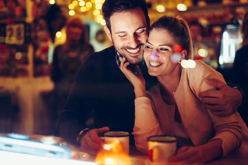 Romantic couple dating in pub at night - obrazy, fototapety, plakaty