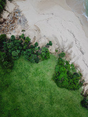 Beach on the beach of the island of Bali. Pink sand and green grass. The view from above is taken from the drone.