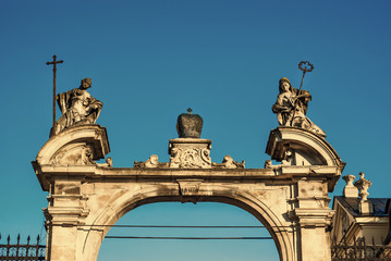 Obraz premium Ancient statues of the eighteenth century above the entrance gate to the cathedral