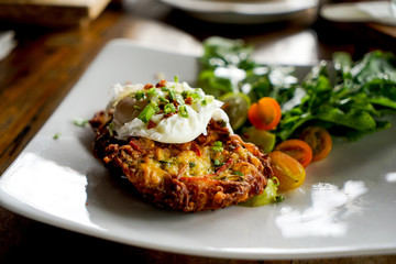 Egg poached with potato hash brown and summer salad. Close-up shot