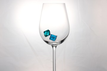 Wine glass with falling ten-sided and six-sided dice