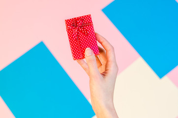 Stylish flat lay with woman hands wrapping holding present. Holiday celebration concept woman hands opening red gift box.
