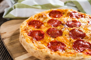 Pepperoni pizza on rustic background