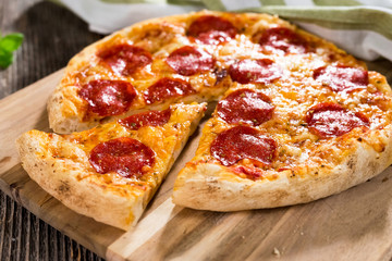 Pepperoni pizza on rustic background