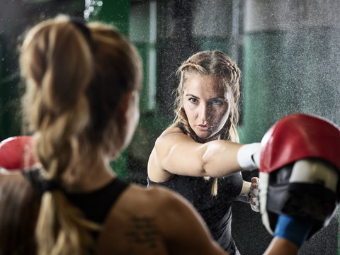 Two women practicing punches