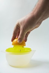 men's hand presses lemon on juicer