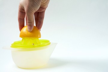 Woomen's hand presses lemon on juicer