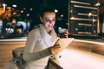 Attractive young woman using tablet in cafe