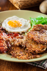 Hash browns. Potato pancakes with crispy fried bacon and fried egg