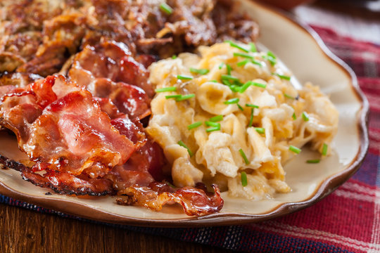 Hash browns. Potato pancakes with crispy fried bacon and scrambled eggs
