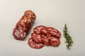 Sliced appetizing Italian sausage salami isolated on white background
