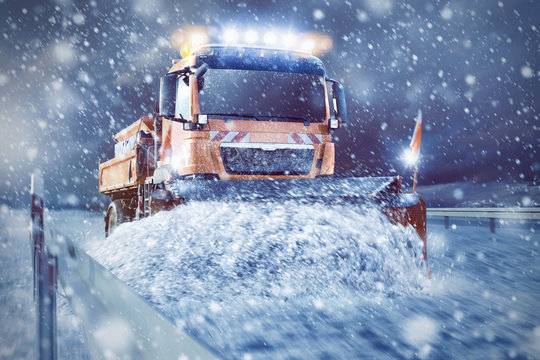 Professioneller Schneepflug auf der Stra&szlig;e