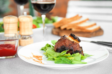 Delicious ribs served for dinner on table