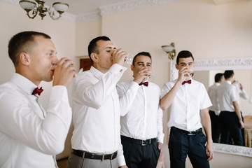 Obraz premium Handsome groom preparing for wedding ceremony in hotel room