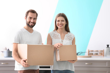 Young couple with boxes indoors. Moving day