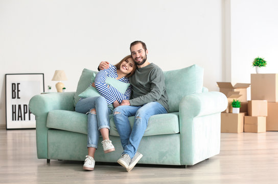 Young couple sitting on sofa after moving to new home