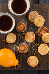 Tea set. Homemade cookies, organic lemon and black tea on dark ribbed oak board