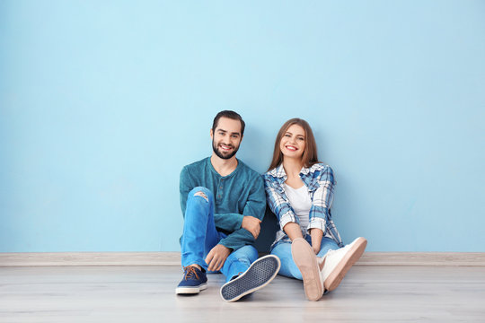 Young couple sitting on floor in empty room. Ready for moving to new house