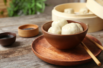 Bowl with tasty baozi dumplings on table