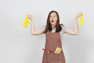 Obraz premium Young sad upset tired shocked housewife in striped apron with cleaning rag in pocket isolated on white background. Pretty housekeeper woman holding yellow gloves in spreading hands. For advertisement.