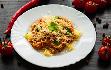 Pasta Spaghetti with tomato sauce and grated cheese on a dark wooden background