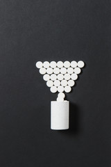 Medication white colorful round tablets arranged abstract on black background. Aspirin, capsule...