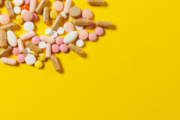 Medication white colorful round tablets arranged abstract on yellow color background. Aspirin,...
