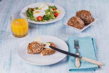 Poached egg with green salad, tomatoes, wholemeal bread and orange juice