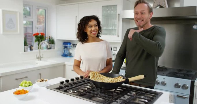 4K Cheerful TV presenters cooking & talking to camera in modern studio kitchen