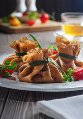 Pancakes with meat, tied with green onions