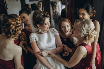 Obraz premium Lovely bride and bridesmaids next to the big window