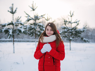 Winter Portrait of cute Caucasian young woman in winter forest