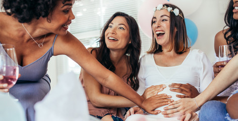 Fototapeta Friends touching pregnant woman's belly at baby shower party obraz