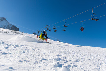 Fototapeta na wymiar Skifahrer fährt die Piste herunter