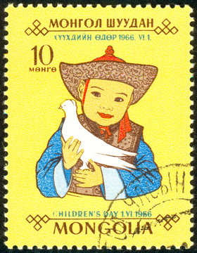 Ukraine - circa 2018: A postage stamp printed in Mongolia show the Mongolian child in a bright national costume holds a white dove in his hands. Series: Day of the child. Circa 1966.