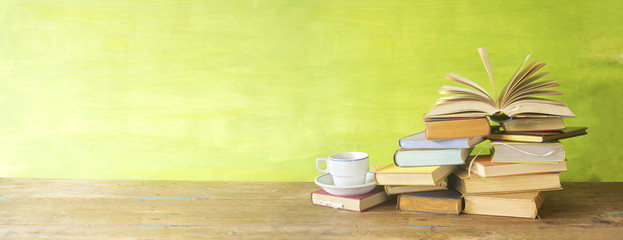 Opened Book on a pile of old books,cup of coffee, panorma, good copy space