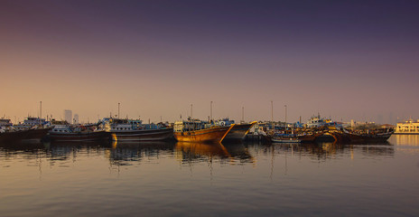 Boats docked in a marina at sunset