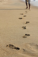 A man walking away leaving footprints in sand