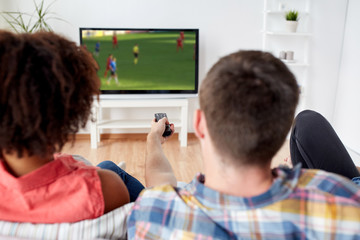 friends watching soccer game on tv at home