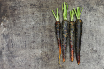 black carrots on a grungy metal background