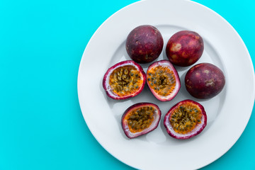 Passion fruit on a white plate on blue napkin Outdoor background