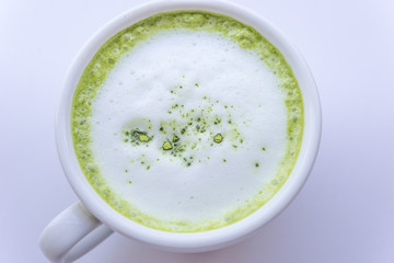 Hot Matcha green tea latte beverage in cup on wooden table.