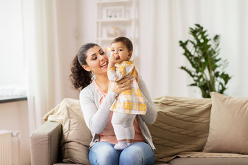happy smiling mother with baby daughter at home