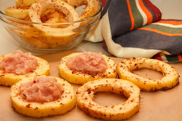 Sliced slices from zucchini, filled with minced meat, on food paper.