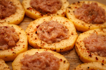 Slices of courgettes stuffed with turkey meat with spices, on food paper. Food background.
