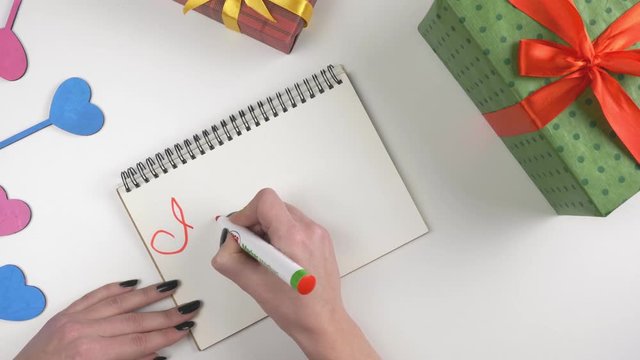 Valentine's Day, illustration, woman's hand writes in a notebook, I love you mom. 60 fps