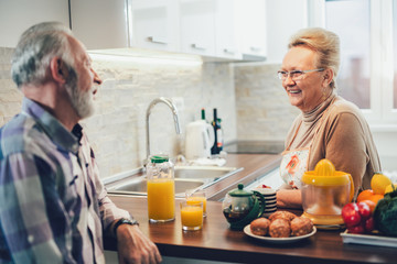 Elderly couple in the kitchen preparing breakfast