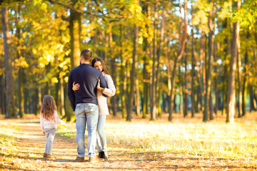 Fototapeta premium mom and dad with daughter at sunset playing